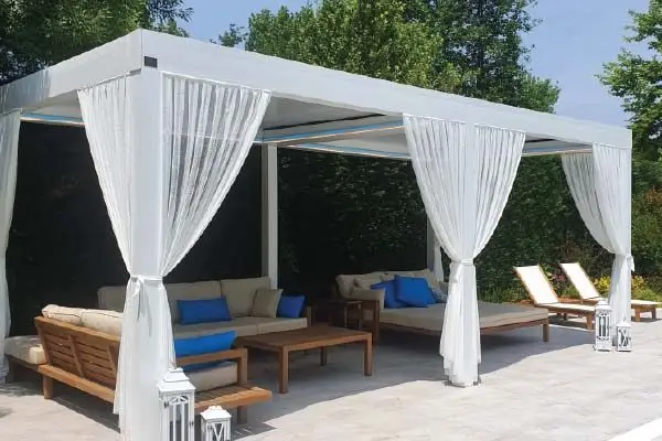 Pérgola bioclimática CostaGlass con lamas en posición semiabierta en terraza de Marbella durante el atardecer